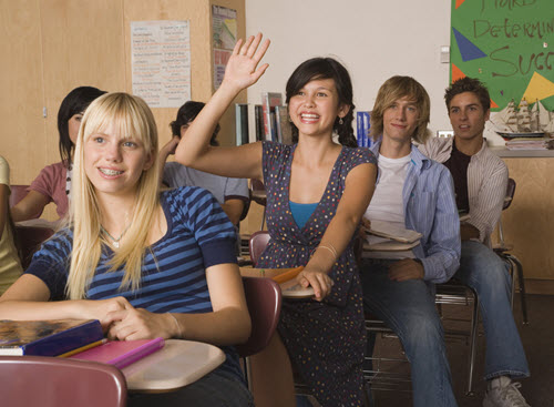 Girl in classroom raises hand to ask a question