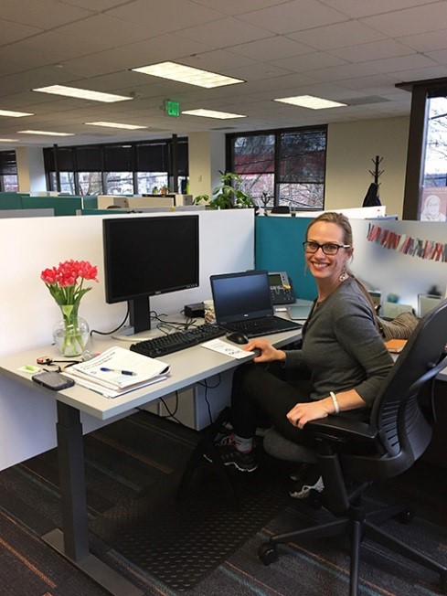 Photograph of Monika Sengul-Jones sitting at desk with computer.