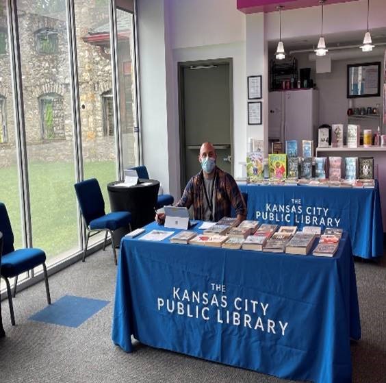 Kansas City Public Library staff welcoming patrons to the theatre and providing library books to check out