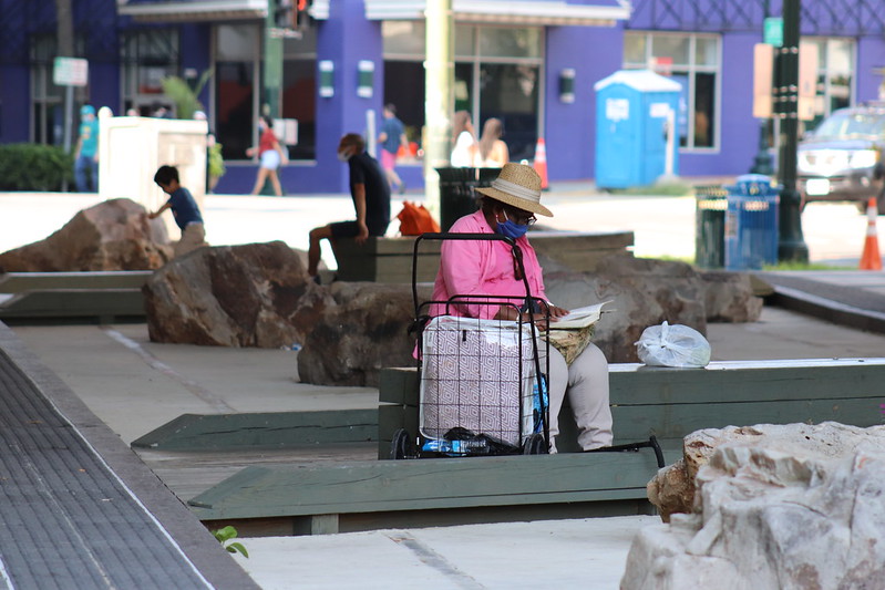 several people sitting outside building in a public area