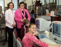 Joan Hubble, Perry Middle School Librarian (l), and Danielle Shreve, Perry (OK) Carnegie Library Director (r), help 5th grader Kristina with a special project, while Brayden practices his computer skills. Photograph by Dawn Pennington.