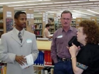 Photo of three people talking in a library