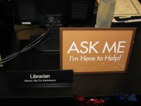 Sign saying "Ask me I'm here to help."