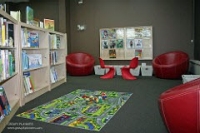 Photo of children's area with chairs, bookshelves and carpet. Photo of children's area with chairs, bookshelves and carpet.