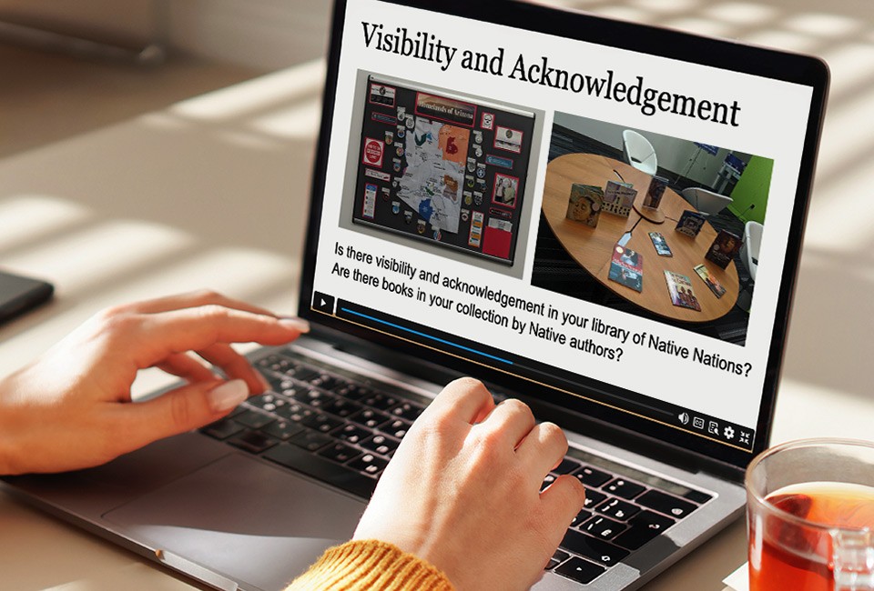 close-up of a person's hands hovering above a laptop keyboard, with the screen reading 'visibility and acknowledgement'