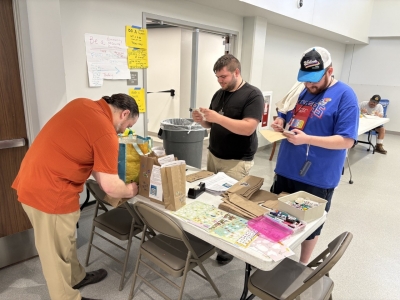3 men writing nots for food bags