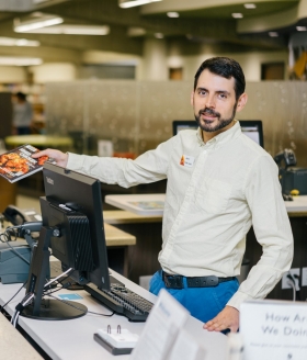 János McGhie, a reference librarian at Saint Paul Public Library, edits Wikipedia to make offline references more accessible online. Credit: Courtesy János McGhie Photo of János McGhie working at a library.