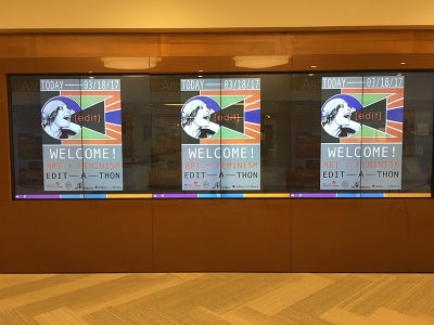 Photo three identical posters welcoming people to the Editathon