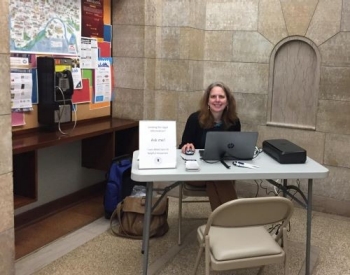 Librarian sitting at a table with resources