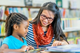 Librarian reading with one child