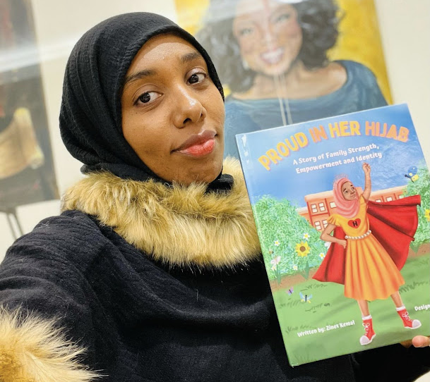Woman holding a book called “Proud in Her Hijab”