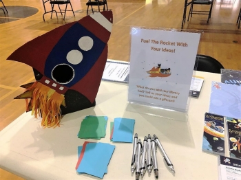 Large cardboard rocket ship, which beckoned people to “Fuel the Rocket with Your Ideas!” to respond to the question “what do you wish our library had?” Large cardboard rocket ship, which beckoned people to “Fuel the Rocket with Your Ideas!” to respond to the question “what do you wish our library had?”