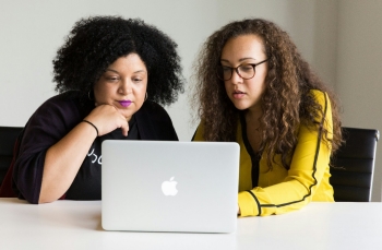 ai-in-use two women looking at the screen of a MacBook